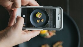 Fotografuojama tobulai išdėstyto gurmaniško maisto lėkštė